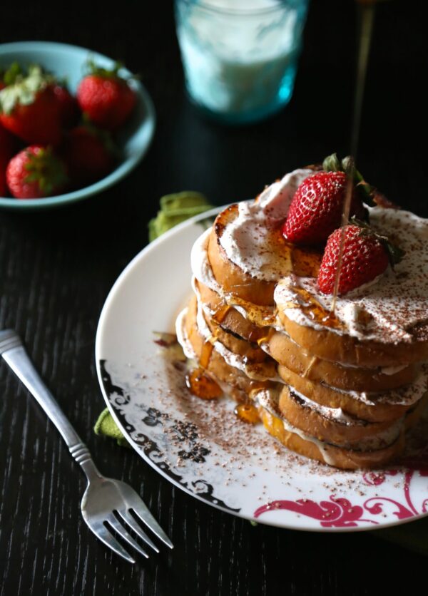 Tres leches french toast with cinnamon whipped cream and strawberries.