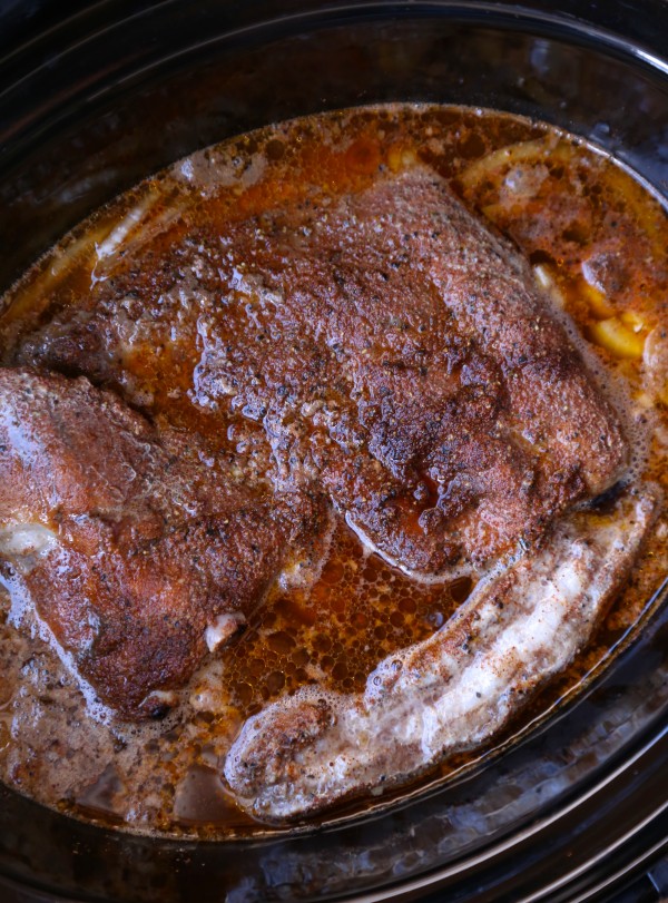 Baby back ribs with spice rub in a pan.