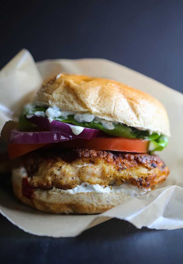 Fried Chicken Shawarma Sandwich with tomato, onion, and lettuce.