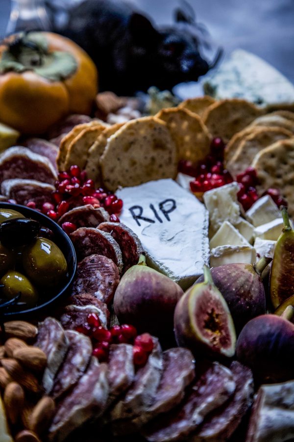 Close-up of brie cheese shaped into a coffin with "RIP" written on top.