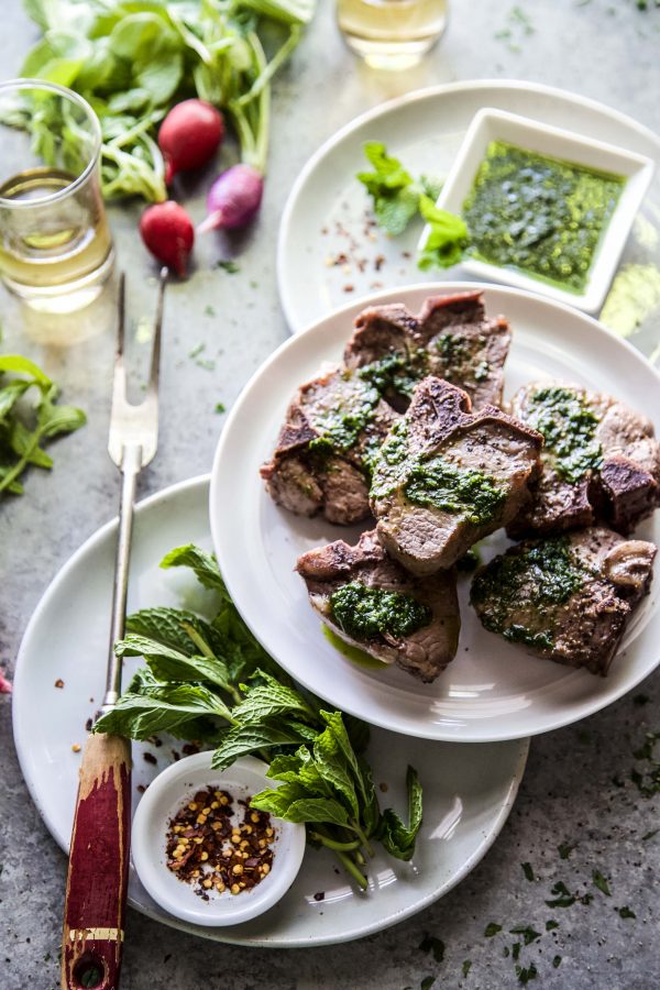 seared lamb loin chop with spinach salsa verde on a table 