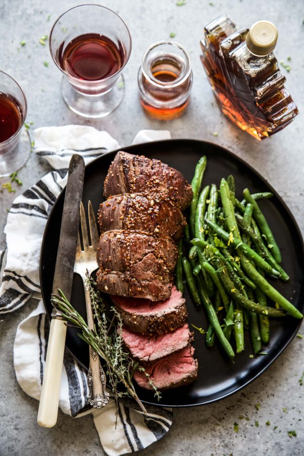 roasted beef tenderloin on a plate with green beans