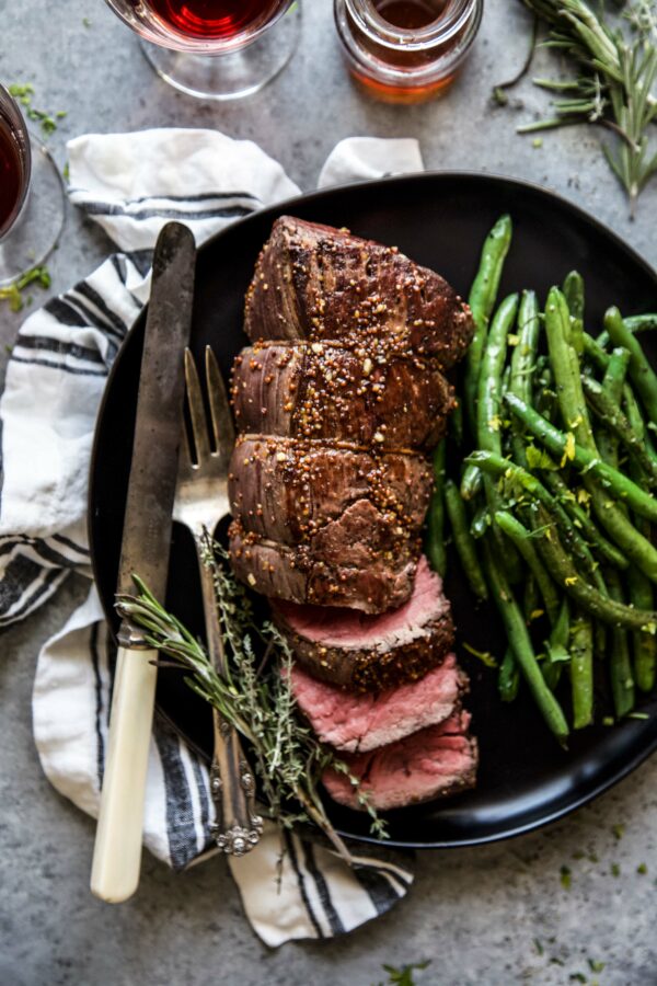 roasted beef tenderloin on a plate with green beans