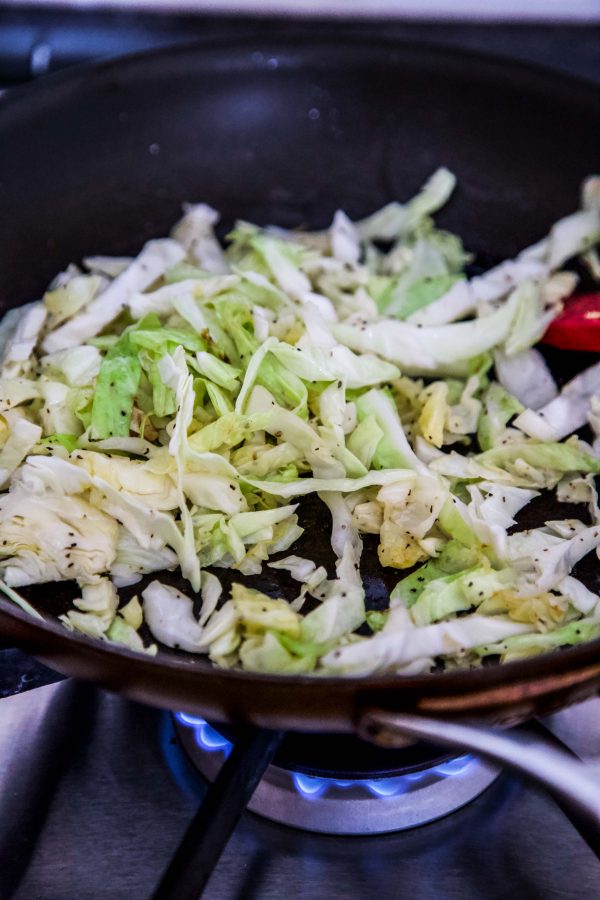 cabbage being sauteed in a skillet