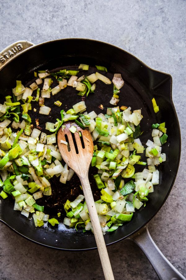 leek and onion cooking in a skillet