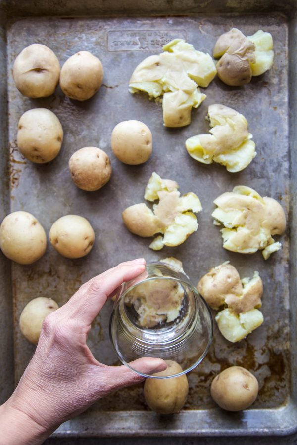 potatoes being smashed with a glass