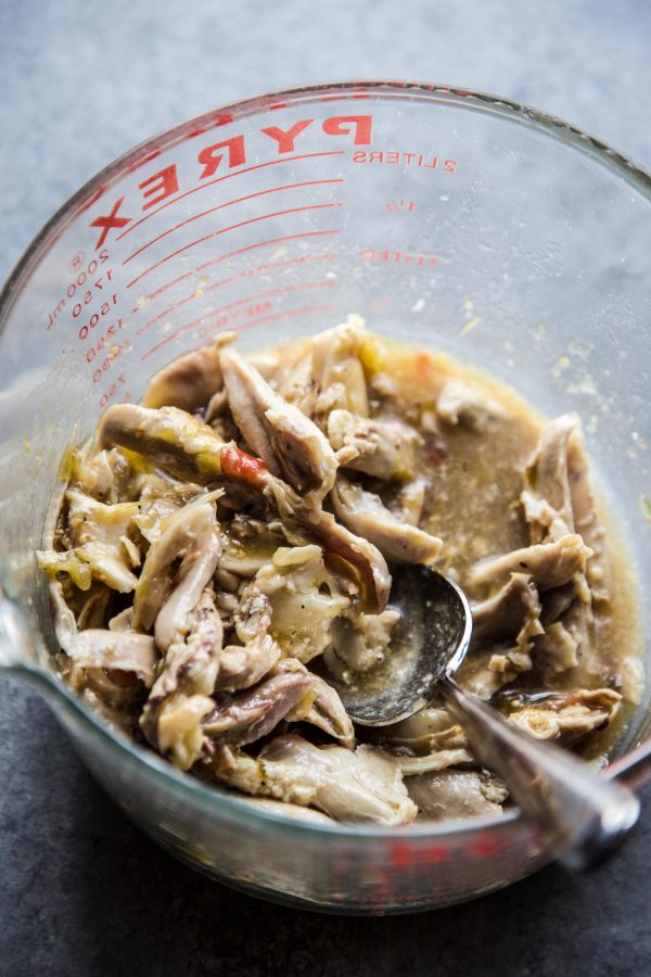 shredded chicken and salsa verde in a mixing bowl