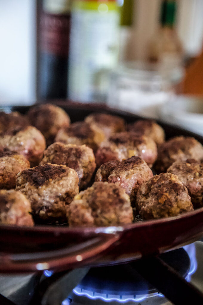 meatballs getting seared in a skillet