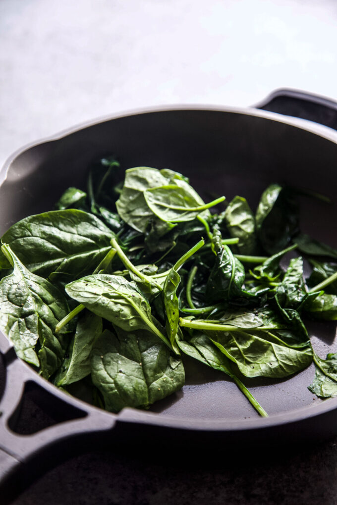 fresh spinach cooking in a skillet