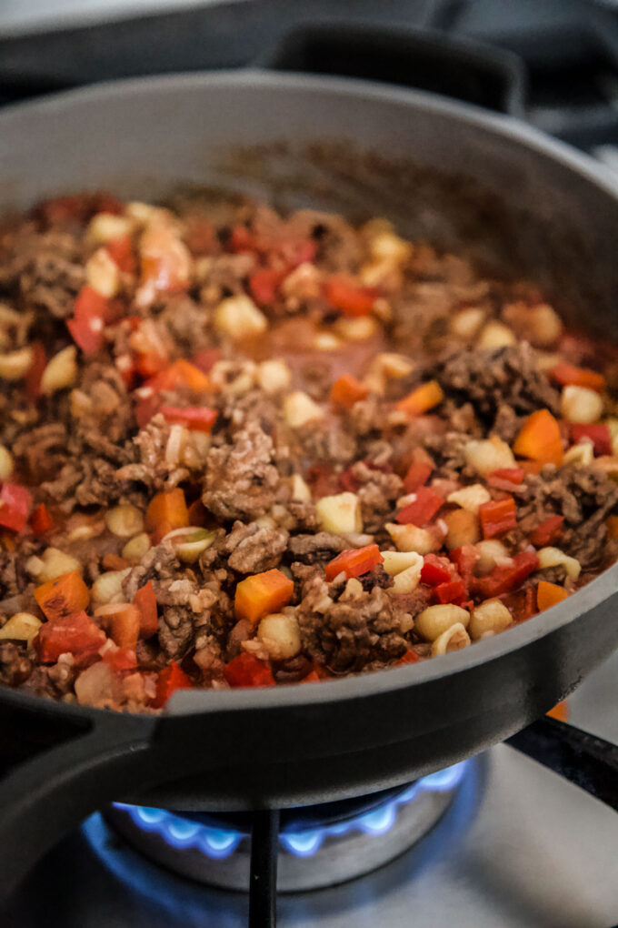 Turkey Sloppy Joe ingredients cooking in a skillet on the stove.