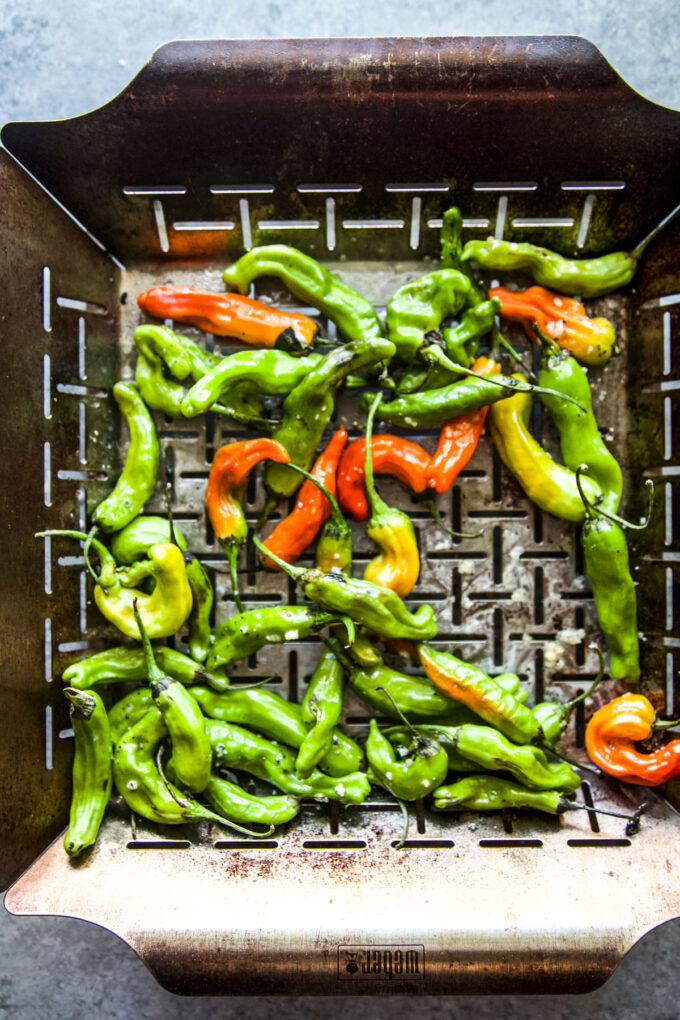 shishito peppers in a grilling basket