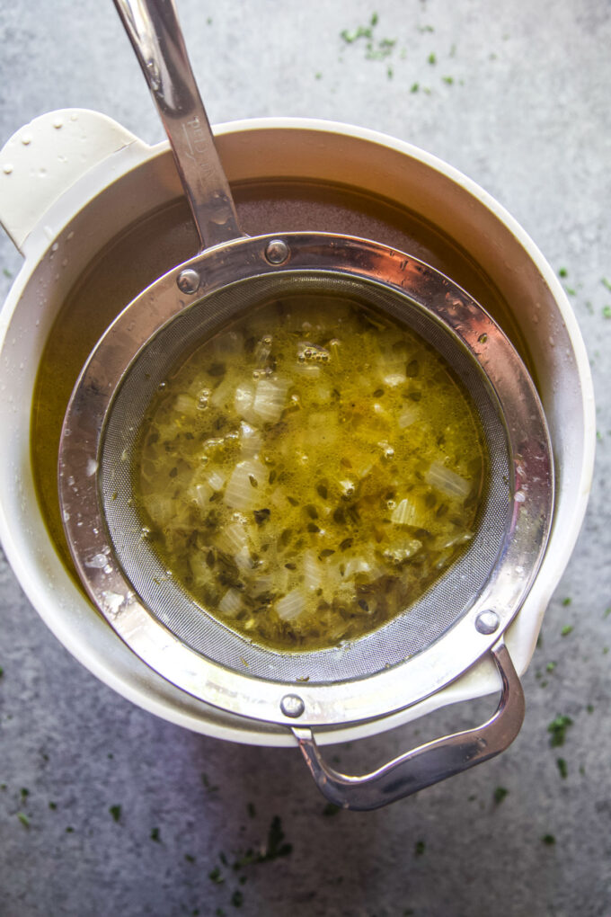 straining the turkey stock to remove solids from liquid