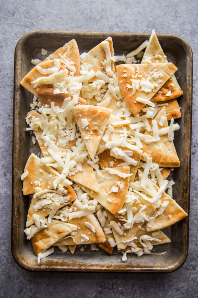 pita chips covered with shredded cheese