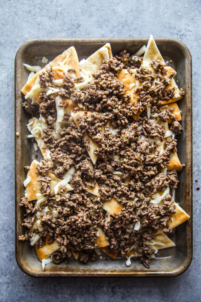 pita chips covered with shredded cheese and ground beef