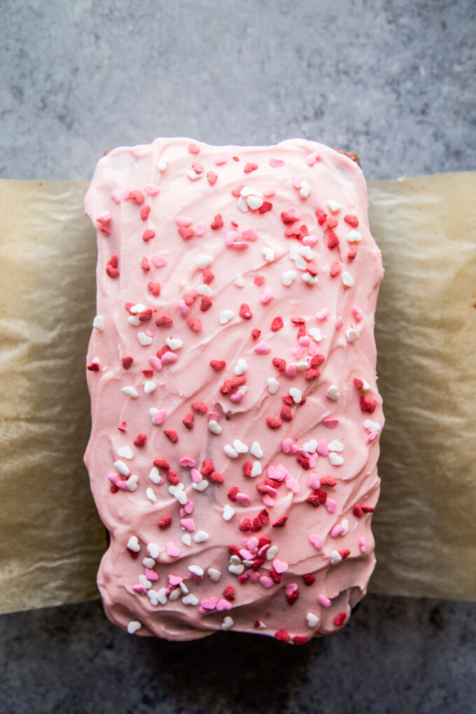 chocolate loaf cake with cherry frosting and heart sprinkles