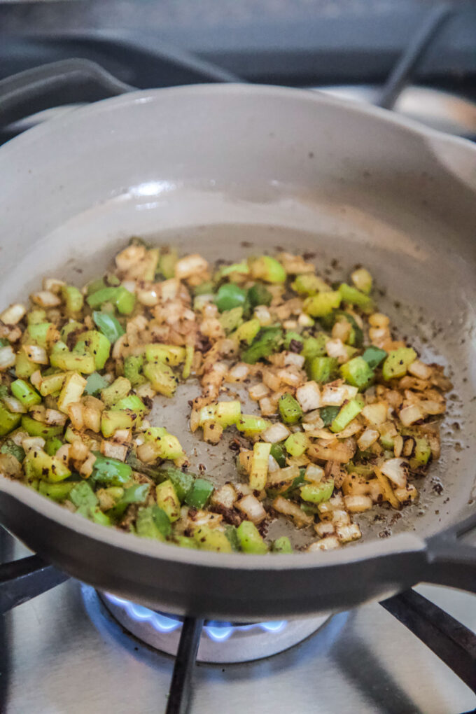 celery, onion, and green pepper cooking in a skillet