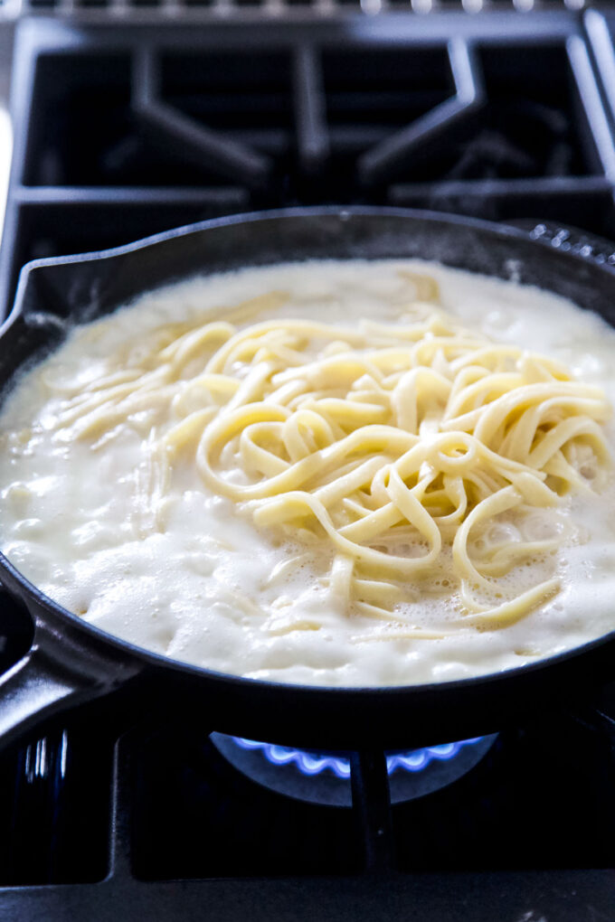 cottage cheese Fettuccine alfredo sauce in a skillet with noodles