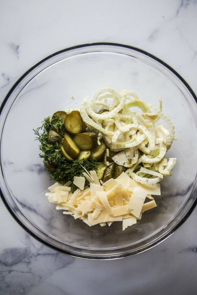 pickles, fennel, parmesan and dill in a bowl