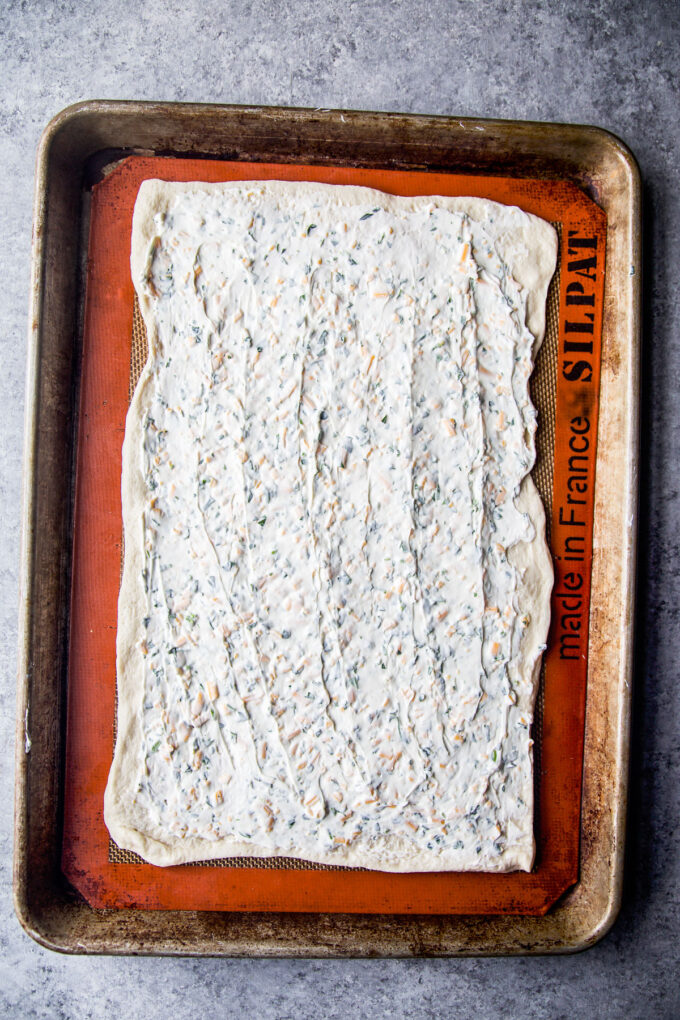 cream cheese spread on pizza dough